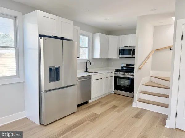 a kitchen with stainless steel appliances a refrigerator and a stove top oven