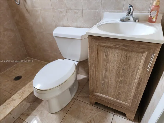 a white toilet sitting next to a bathroom sink
