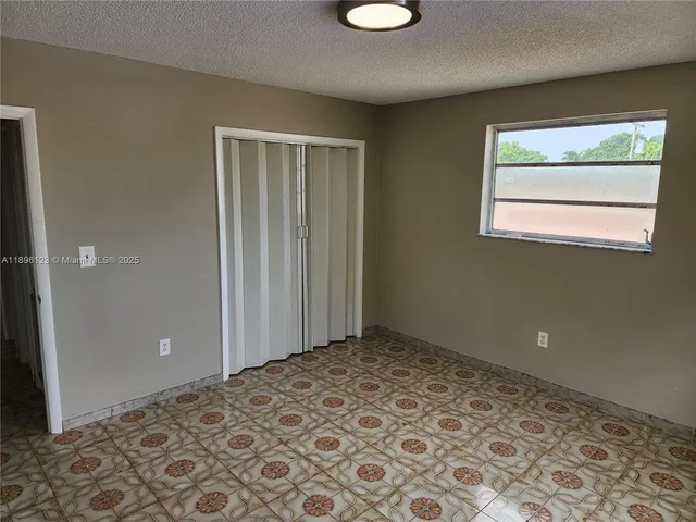 a view of a big room with wooden floor and a bathroom space