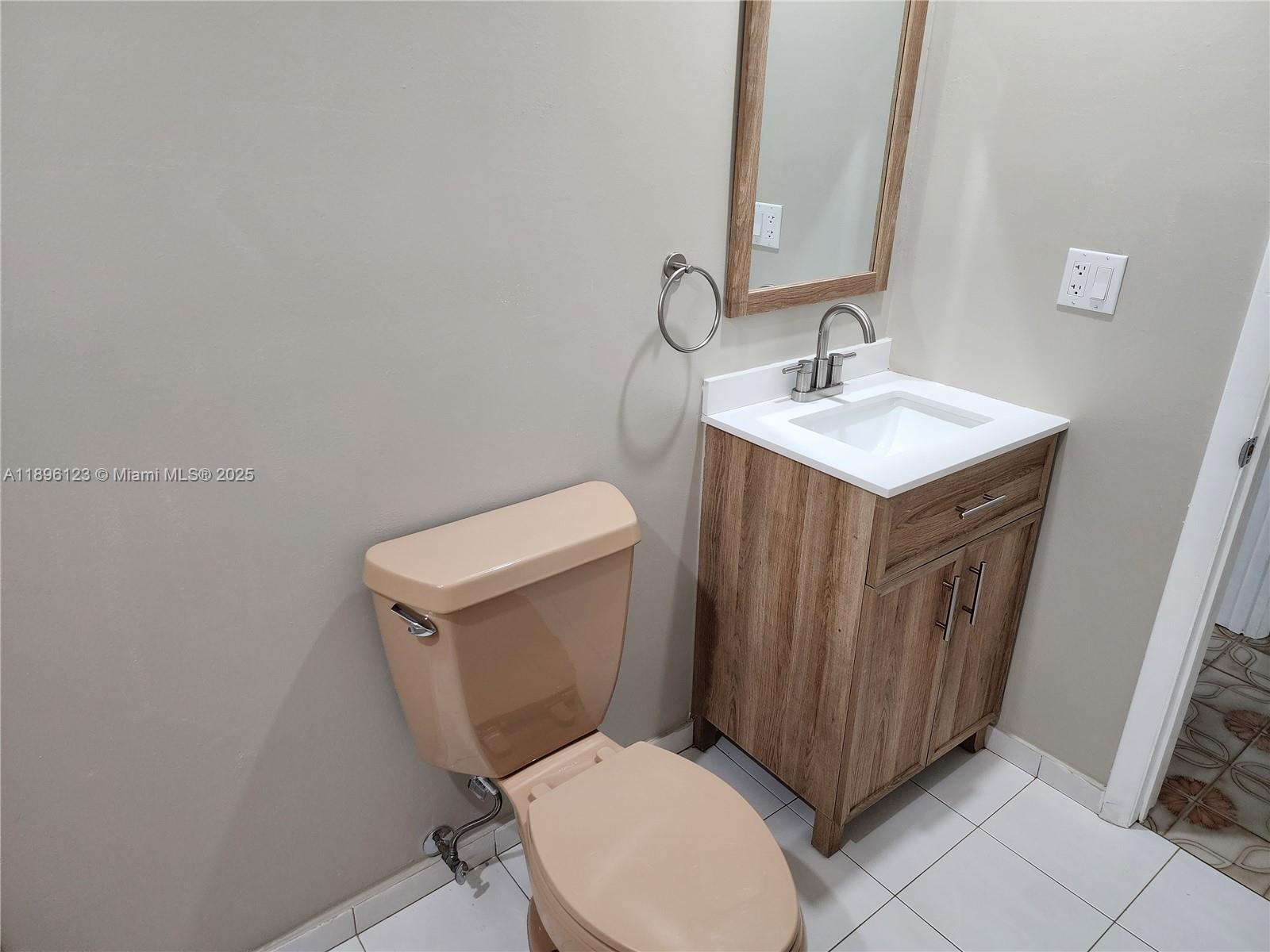 74 East 17th Street, Unit 70 Hialeah, FL 33010 - Photo 37 of 38 a bathroom with a toilet a sink a mirror and vanity