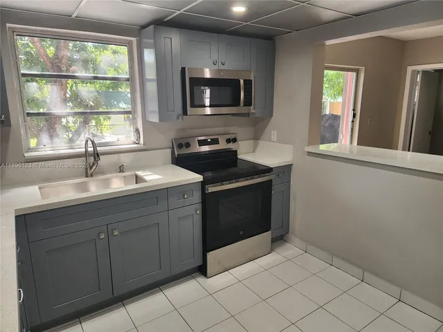 a kitchen with a sink stove and microwave