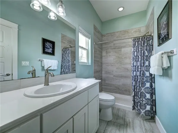 a bathroom with a sink a toilet and shower