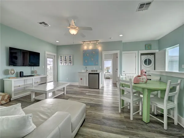 a living room with furniture a flat screen tv and kitchen view