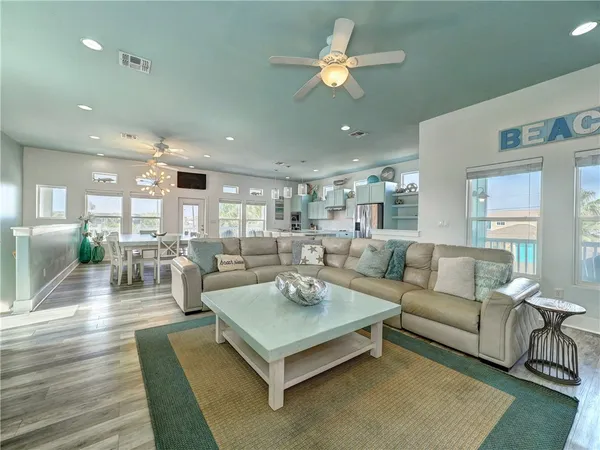 a living room with furniture kitchen view and a large window