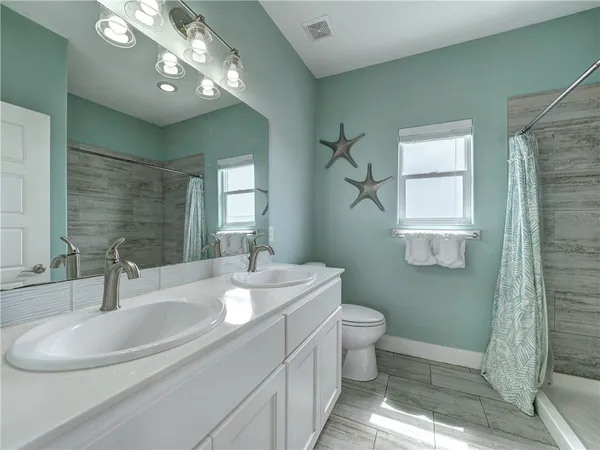 a bathroom with a double vanity sink and a mirror