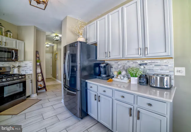 a kitchen with stainless steel appliances granite countertop a refrigerator sink and cabinets