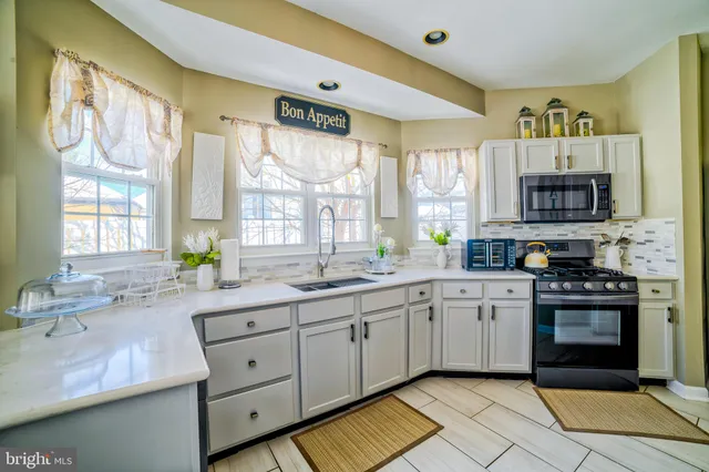 a large kitchen with stainless steel appliances granite countertop a sink and cabinets