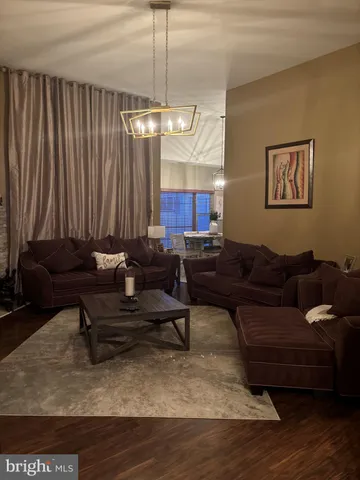 a living room with furniture a chandelier and a rug