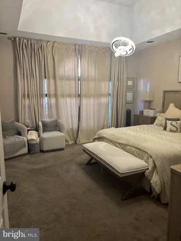a spacious bedroom with a bed and a chandelier