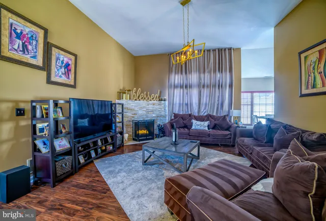 a living room with furniture a flat screen tv and a fireplace