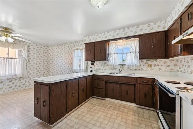 a kitchen with a sink stove top oven and cabinets