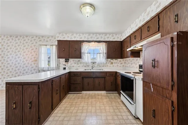 a large kitchen with stainless steel appliances granite countertop a sink stove and refrigerator