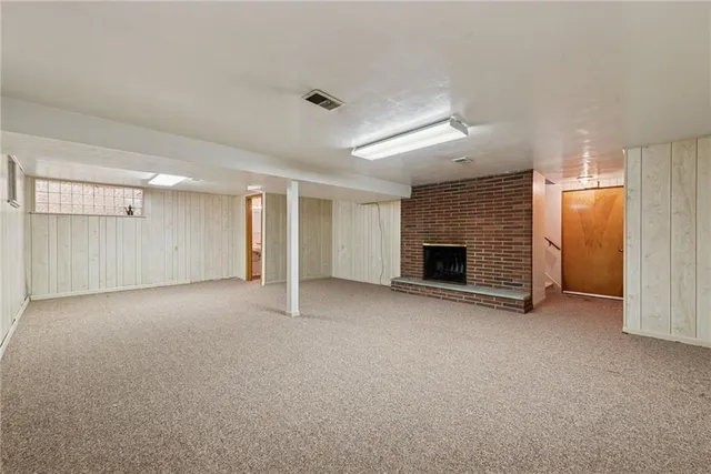 a view of empty room with wooden floor and fireplace