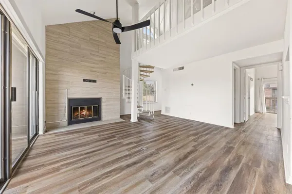 a view of empty room with wooden floor and fireplace