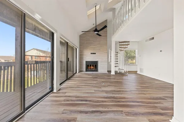 a view of a living room with wooden floor and a fireplace