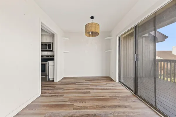 a view of a hallway with wooden floor and staircase