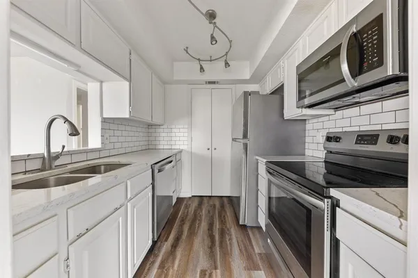 a kitchen with stainless steel appliances granite countertop a sink and a stove