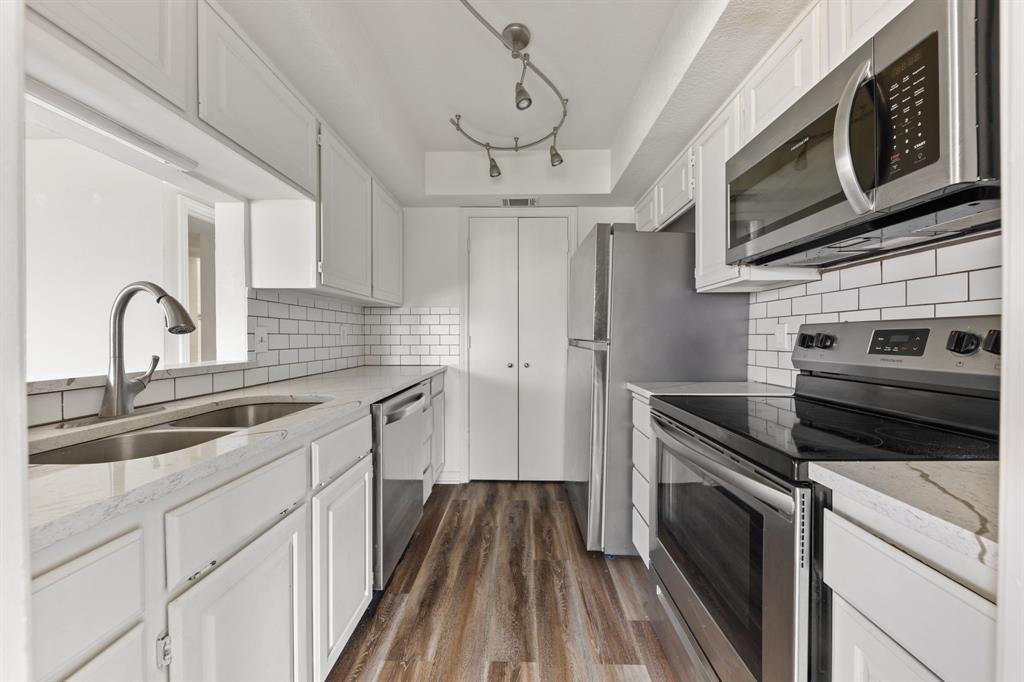 1238 Signal Ridge Place Rockwall, TX 75032 - Photo 7 of 32 a kitchen with stainless steel appliances granite countertop a sink and a stove