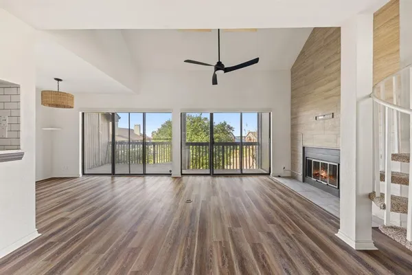 a view of empty room with wooden floor and fireplace