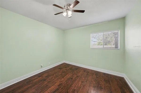 a view of a room with wooden floor and a ceiling fan