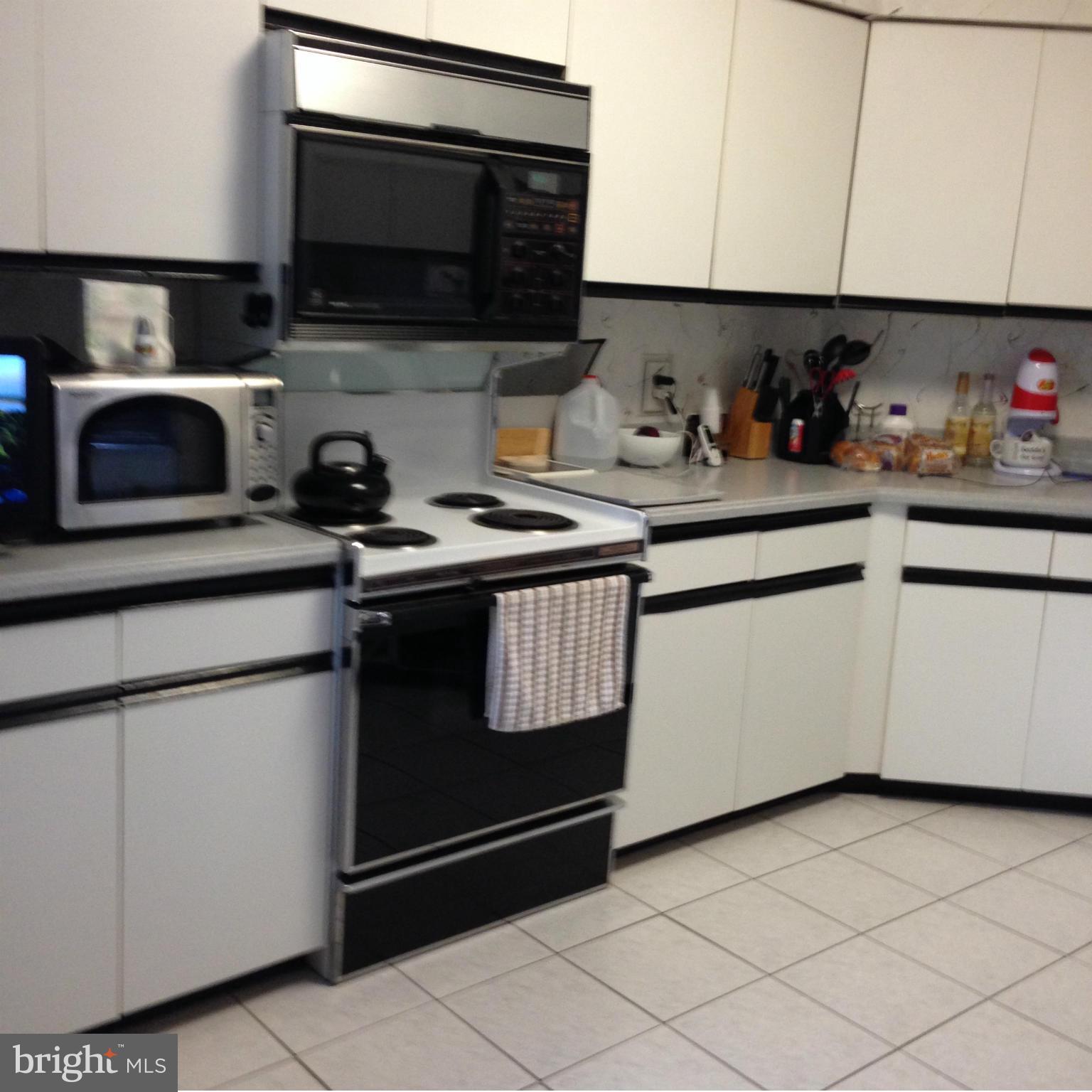 3031 Fallstaff Road, Unit 602C Baltimore, MD 21209 - Photo 3 of 13 a kitchen with stainless steel appliances granite countertop a sink and a microwave