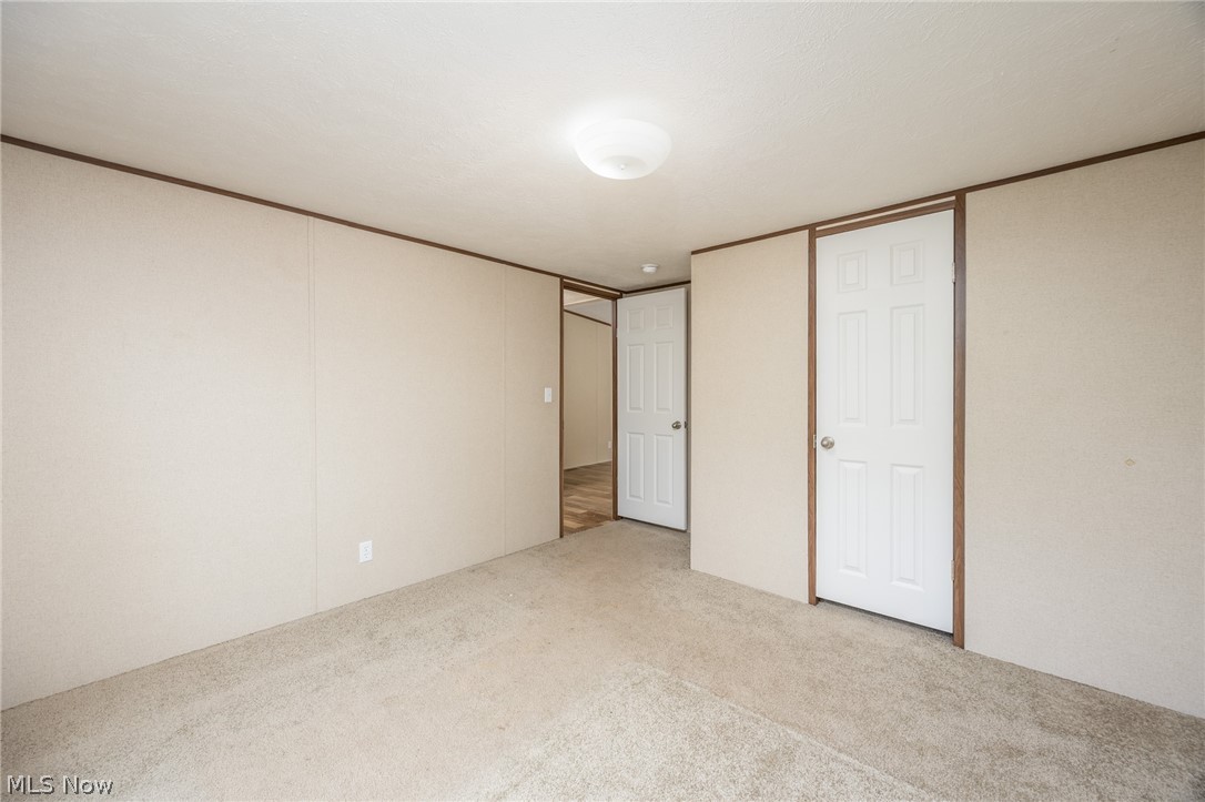 7455 Stanleyville Road Whipple, OH 45788 - Photo 28 of 37 Carpeted room with paneled walls, white trim doors, and a ceiling-mounted light fixture