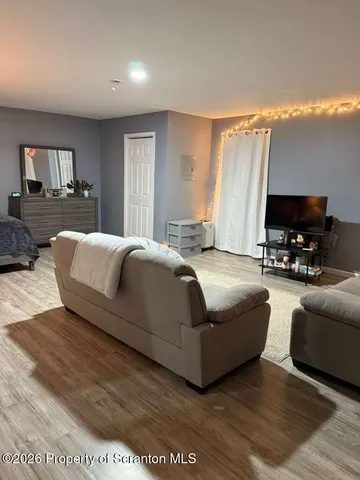 a living room with furniture a flat screen tv and a large window