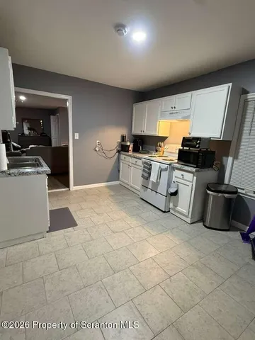 a kitchen with stainless steel appliances granite countertop a sink and a stove