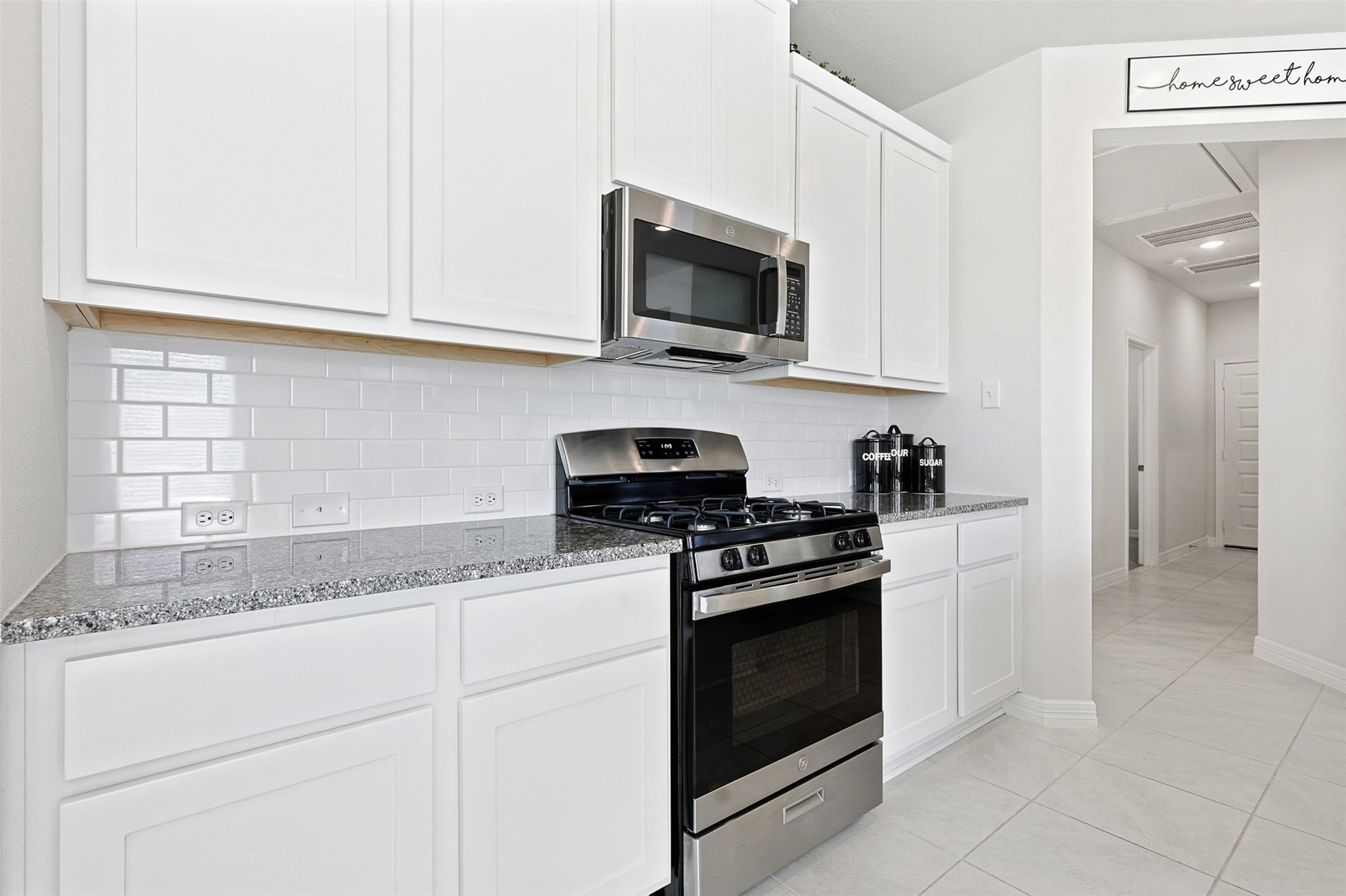 2773 Bluebonnet Ridge Drive Conroe, TX 77304 - Photo 4 of 23 a kitchen with granite countertop white cabinets and stainless steel appliances