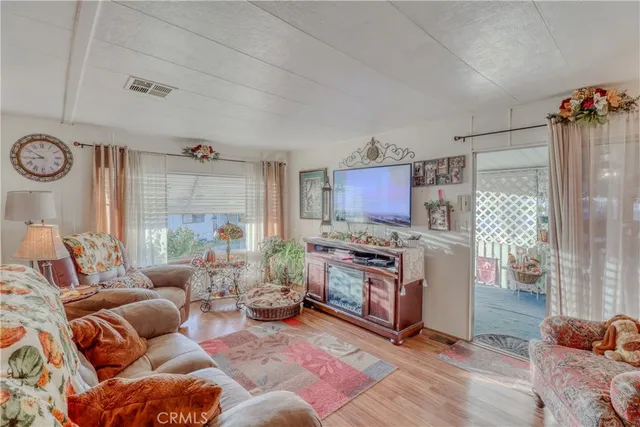 a living room with furniture a flat screen tv and a table
