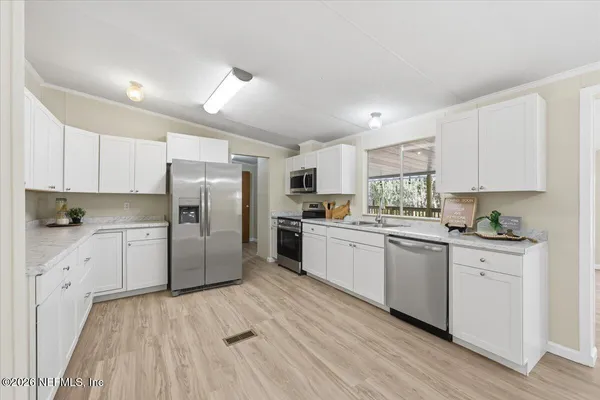 a kitchen with white cabinets stainless steel appliances and sink