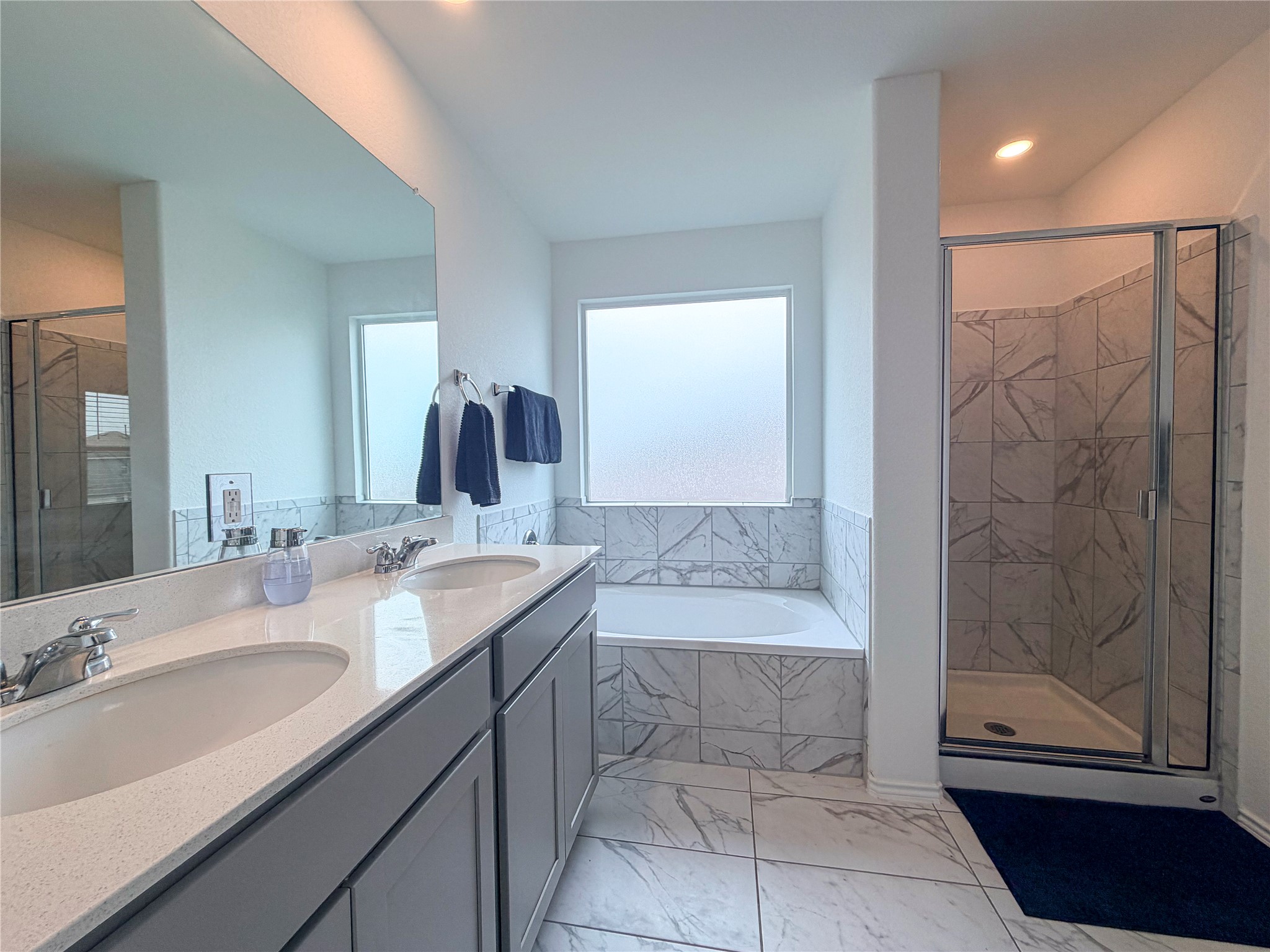400 Canley Loop Hutto, TX 78634 - Photo 15 of 20 a bathroom with a granite countertop sink a mirror and a bathtub