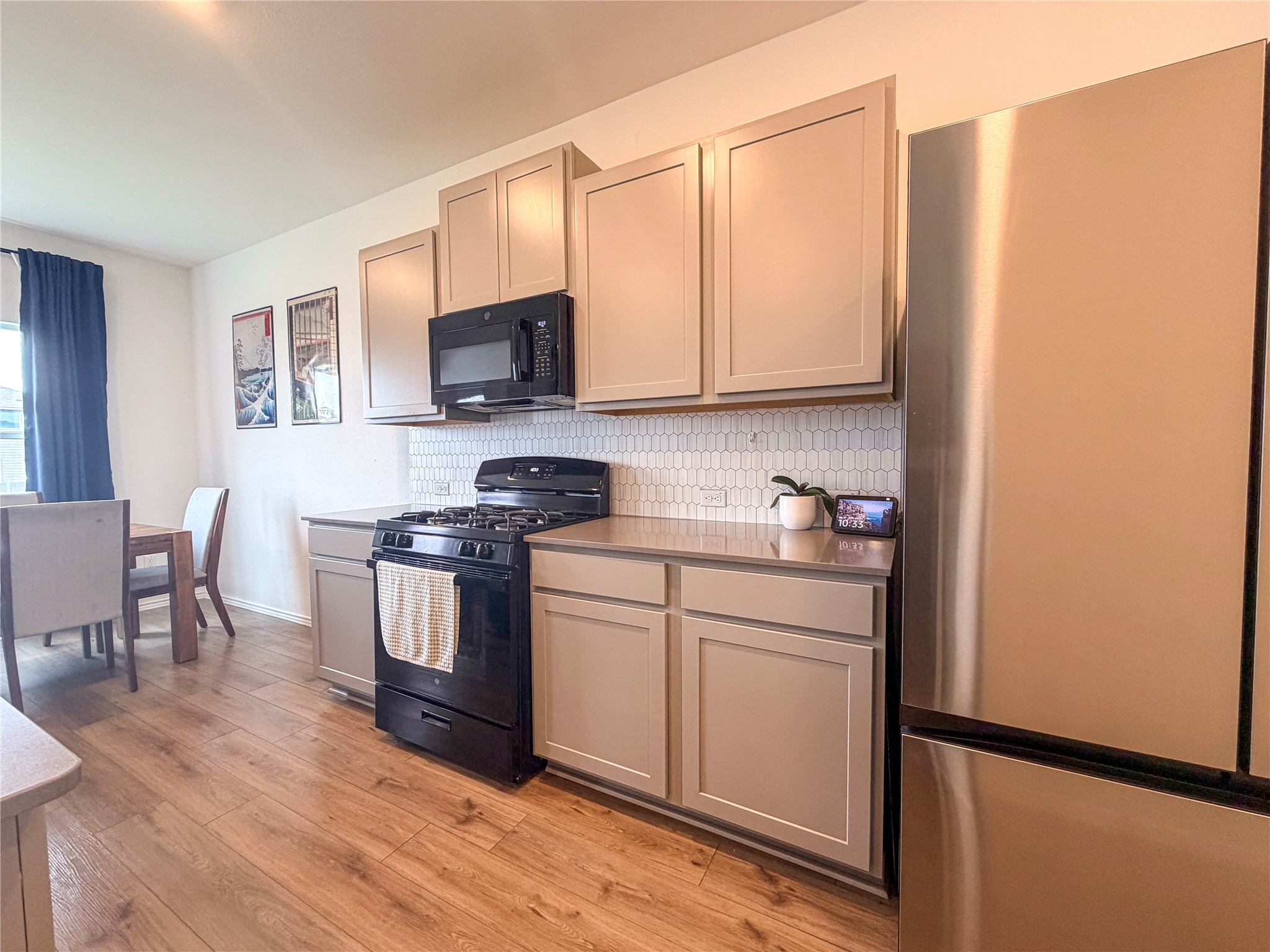 400 Canley Loop Hutto, TX 78634 - Photo 9 of 20 a kitchen with stainless steel appliances granite countertop a stove top oven a sink dishwasher and a refrigerator with wooden floor