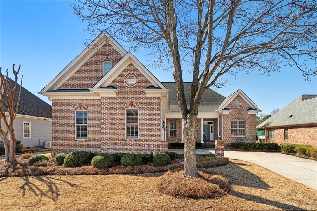 This classic brick residence features an inviting facade and well-maintained landscaping.