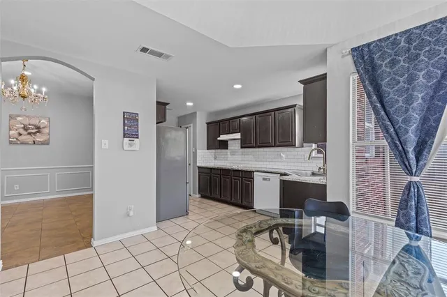 a kitchen with stainless steel appliances kitchen island granite countertop a refrigerator and a stove top oven