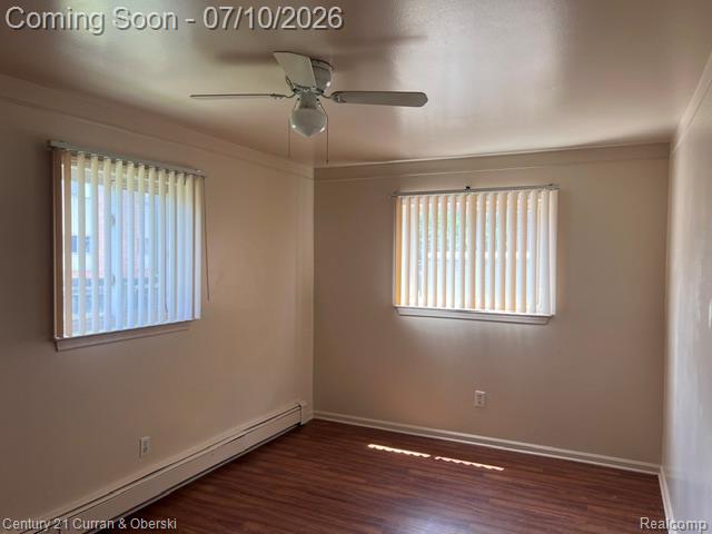 14682 Middle Gibraltar Road, Unit 24 Rockwood, MI 48173 - Photo 8 of 21 Two BIG bed
rooms !!!
Room featuring wood-finish flooring, two windows with vertical blinds, a ceiling fan with integrated lighting, and baseboard heating