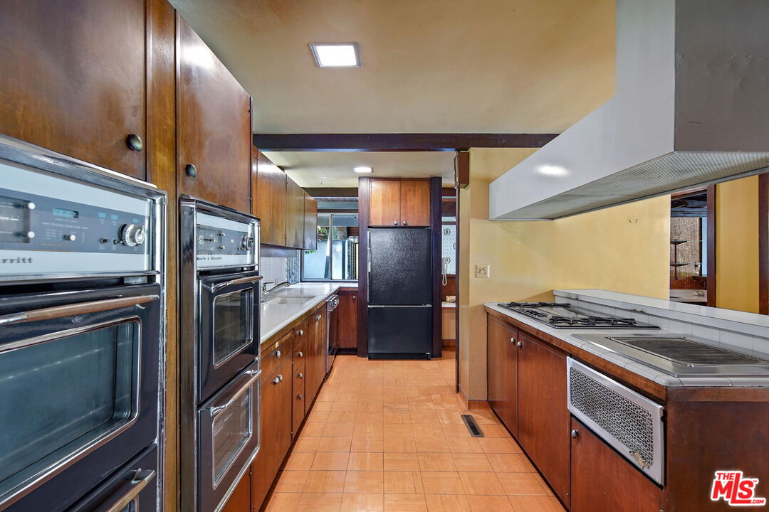 1335 Shadybrook Drive Beverly Hills, CA 90210 - Photo 14 of 39 a kitchen with stainless steel appliances granite countertop a stove and a refrigerator