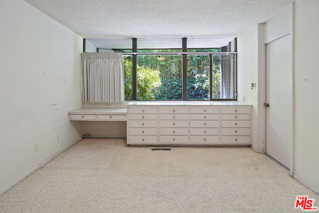 1335 Shadybrook Drive Beverly Hills, CA 90210 - Photo 30 of 39 a view of an empty room with wooden floor and a window