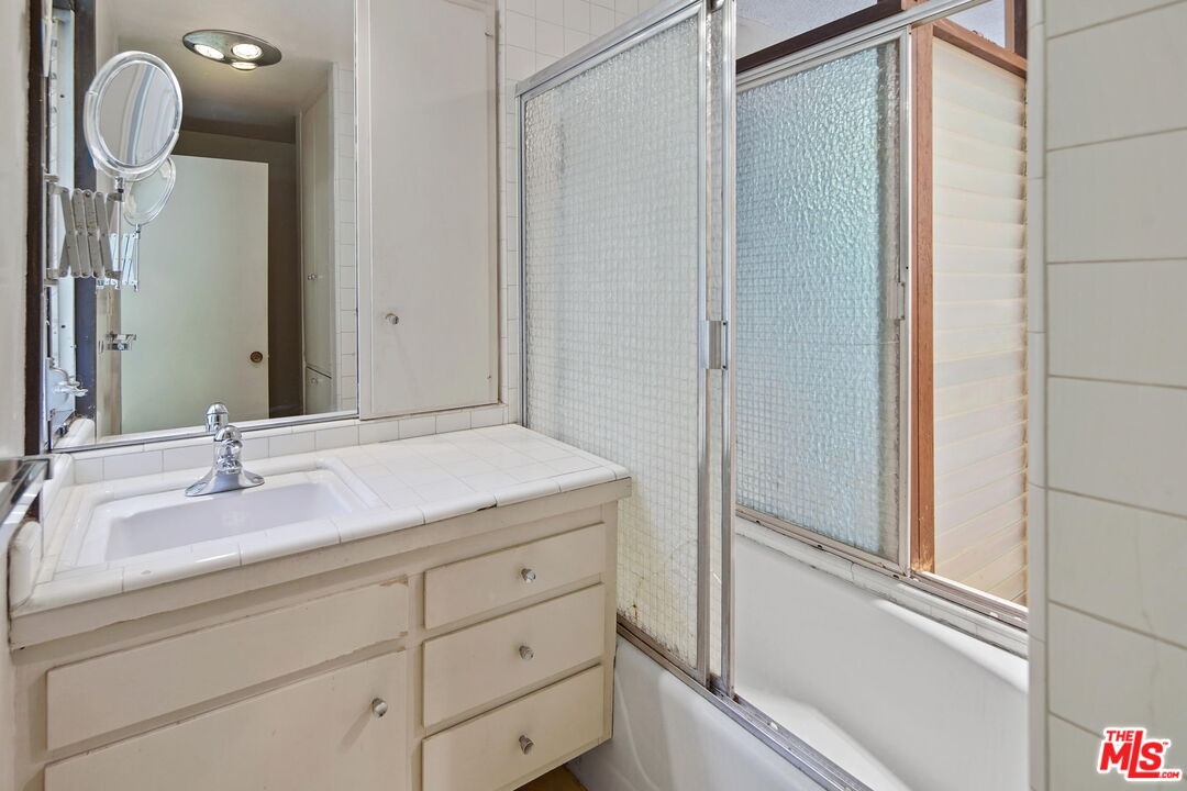 1335 Shadybrook Drive Beverly Hills, CA 90210 - Photo 31 of 39 a bathroom with a granite countertop sink and a mirror