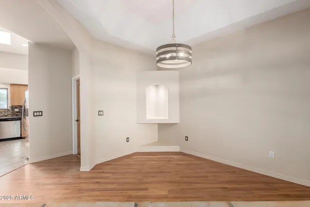 a view of empty room with wooden floor and window