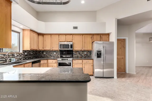 a kitchen with stainless steel appliances a refrigerator sink and stove