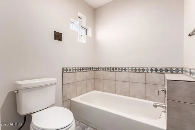 a white toilet sitting next to a white bath tub