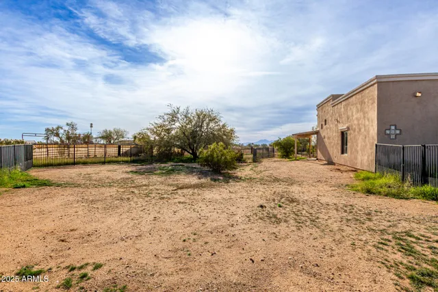 a view of a dry yard with wooden fence