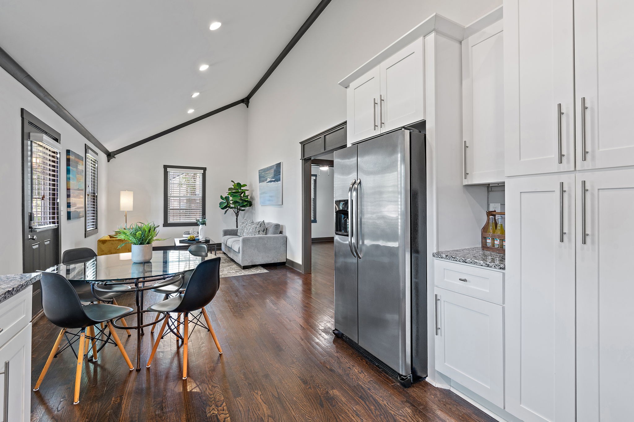 2614 Live Oak Road Nashville, TN 37210 - Photo 11 of 37 a kitchen with stainless steel appliances a refrigerator a stove a dining table and chairs with wooden floor