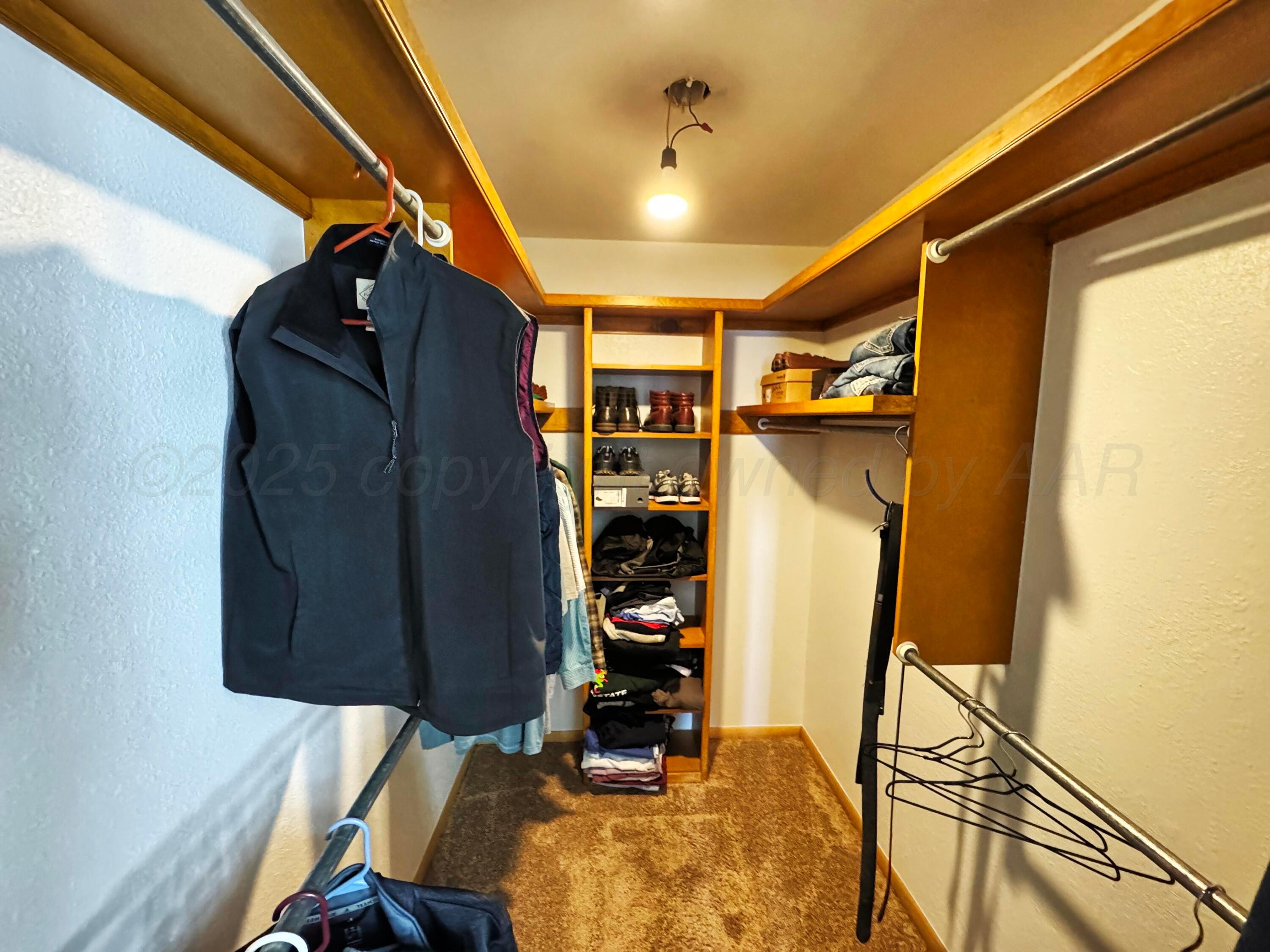 12885 Highway 83 Perryton, TX 79070 - Photo 15 of 40 a view of walk in closet with clothes and shoes