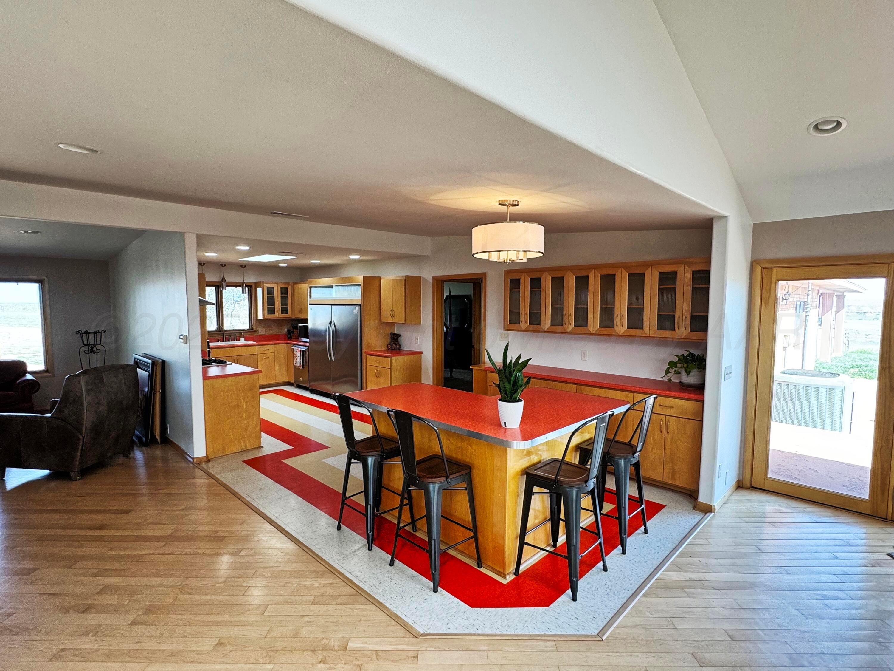 12885 Highway 83 Perryton, TX 79070 - Photo 4 of 40 a living room with furniture a dining table wooden floor and a large window