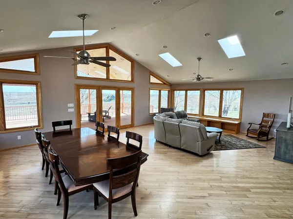 a living room with furniture a dining table and a large window