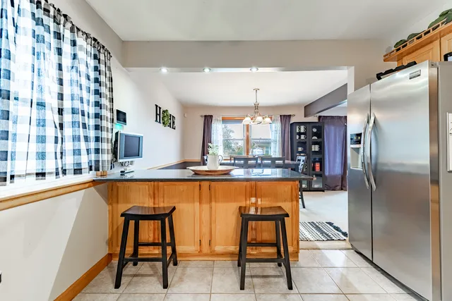 a large kitchen with kitchen island a large window and stainless steel appliances