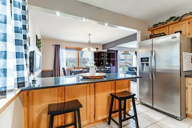 a kitchen with stainless steel appliances granite countertop a refrigerator a stove and a sink with cabinets