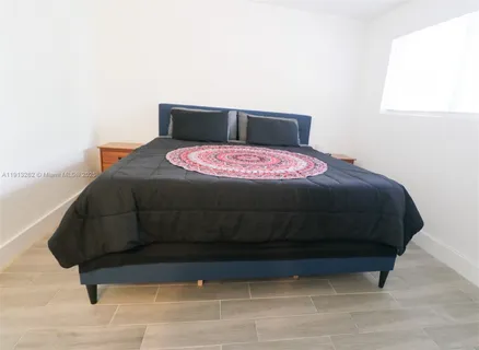 a bed sitting in a bedroom next to a window